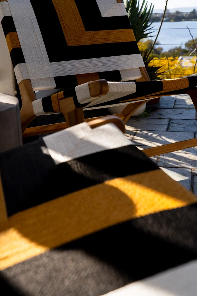 Geometric black, white and yellow woven chair in sunlight.