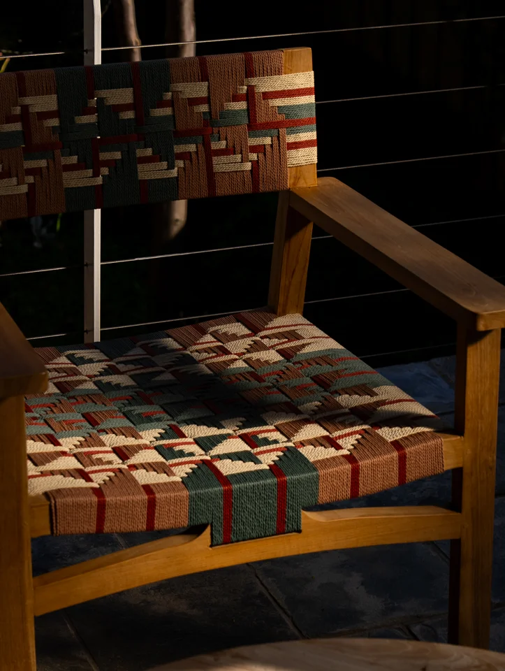 Colourful woven chair details in patterned sunlight and shadow.