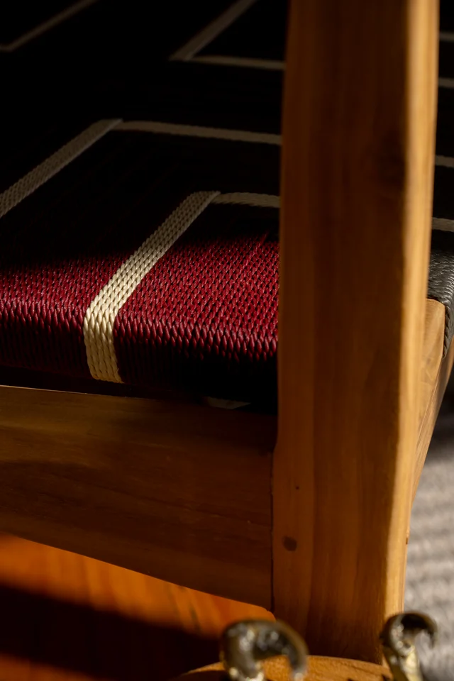 Close-up of wooden furniture and woven upholstery in warm light.