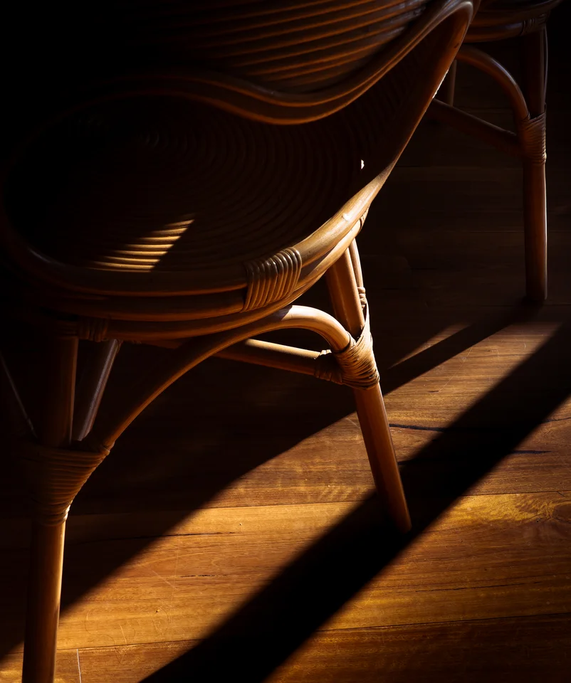 Curved woven wooden seating illuminated by warm sunlight.
