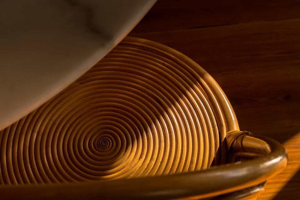 Curved woven wooden seating illuminated by warm sunlight.
