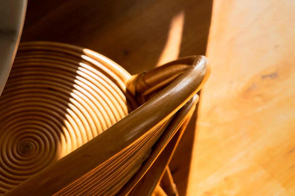 Curved woven wooden seating illuminated by warm sunlight.