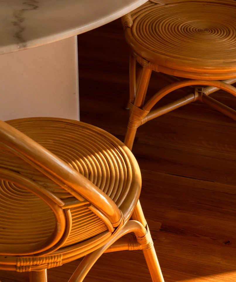 Curved woven wooden seating illuminated by warm sunlight.