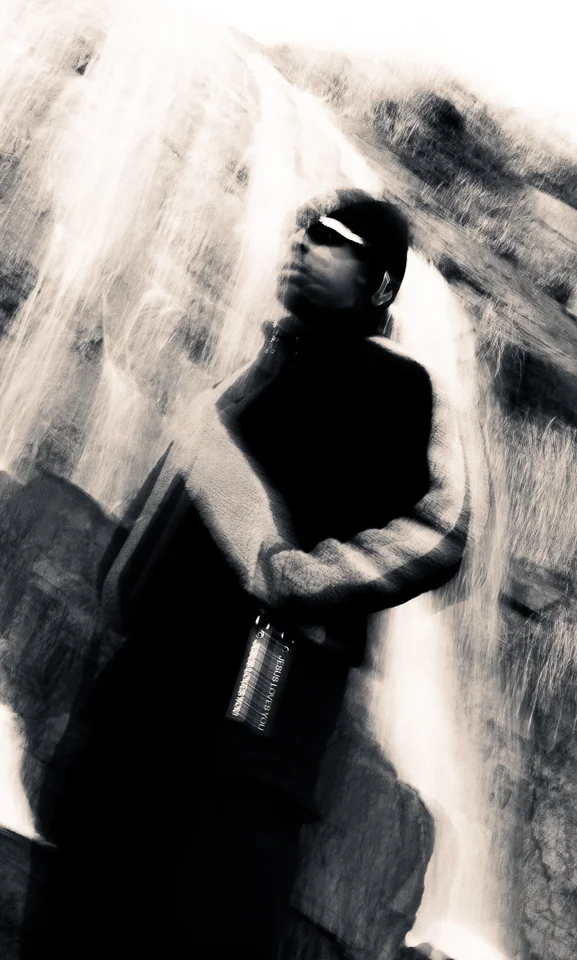 Motion-blurred fashion portrait in front of a waterfall.