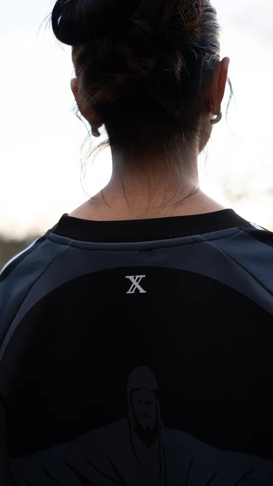 Back detail of a dark graphic T-shirt worn outdoors.