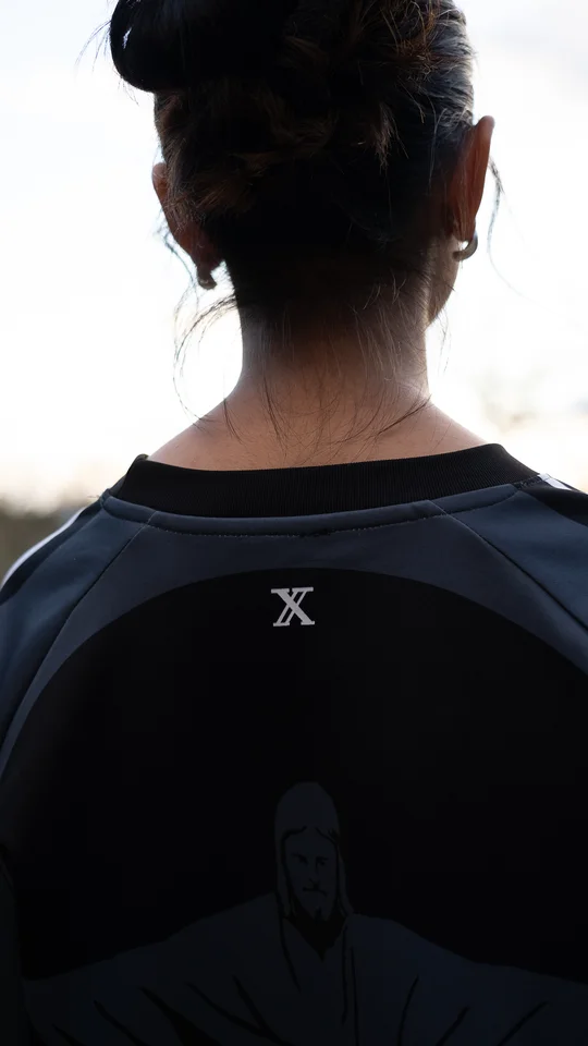 Back detail of a dark graphic T-shirt worn outdoors.