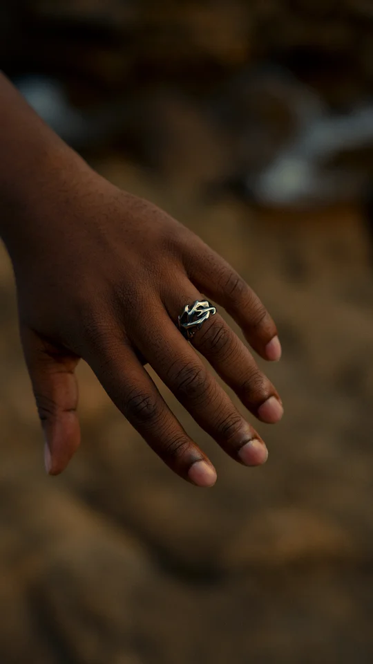 Close-up of a silver ring on a hand against a softly blurred background.