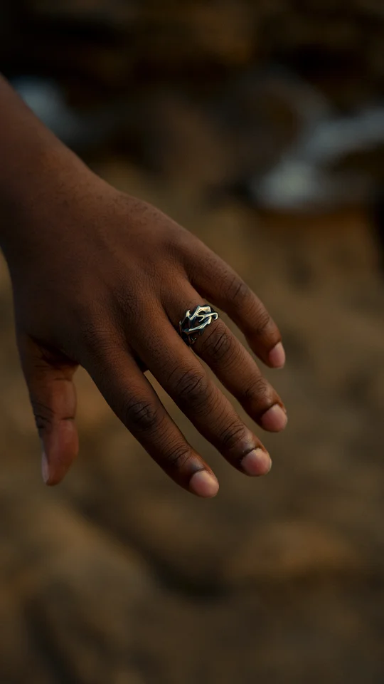 Close-up of a silver ring on a hand against a softly blurred background.