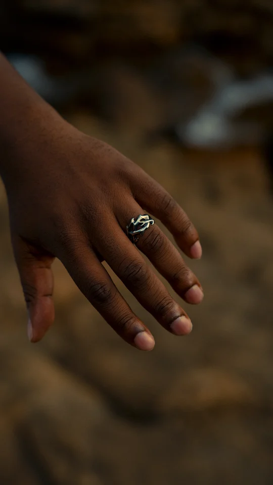 Close-up of a silver ring on a hand against a softly blurred background.