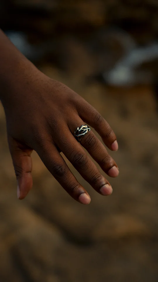 Close-up of a silver ring on a hand against a softly blurred background.