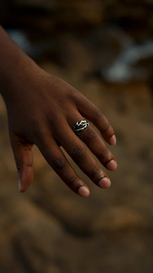 Close-up of a silver ring on a hand against a softly blurred background.