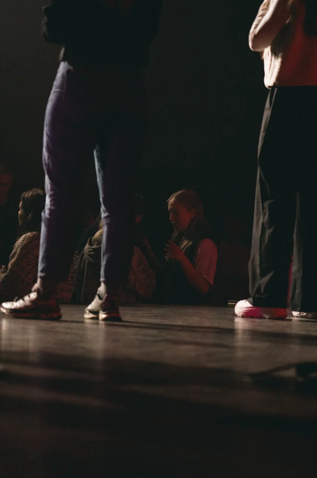 Low-angle view of performers on stage with the audience beyond.